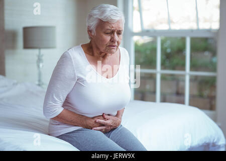 Senior donna che soffre di dolori di stomaco Foto Stock