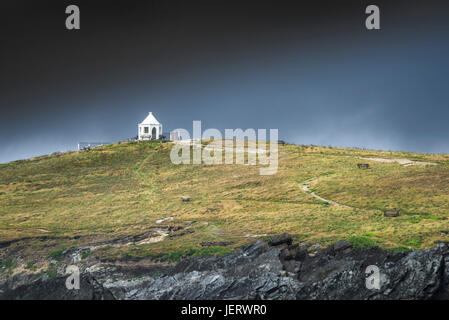 Dark rainclouds raccolta su una piccola vedetta bianco edificio sulla sommità del promontorio Towan in Newquay, Cornwall. Foto Stock