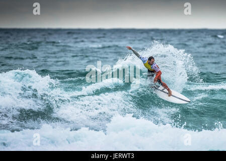 Navigare in UK. Spettacolare azione di surf come un surfista cavalca un onda in un concorso a Fistral Beach in Newquay Cornwall, Foto Stock