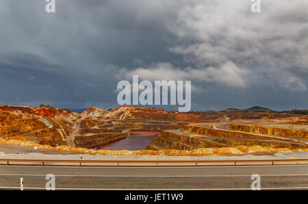 Rio Tinto miniera e strada a giorno tempestoso, ampio angolo Foto Stock