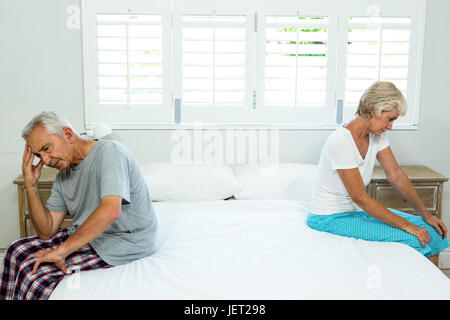 Triste senior l uomo e la donna seduta sul letto Foto Stock