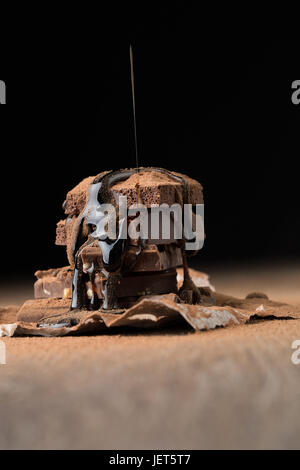 Cioccolato poroso cosparso con sciroppo tavolo in legno su sfondo nero Foto Stock