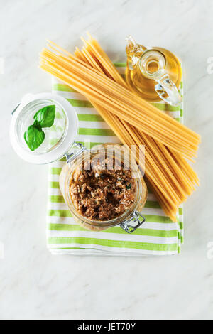 Italiano tipo di spaghetti bucatini e pesto di melanzana in vaso su marmo bianco tabella Foto Stock