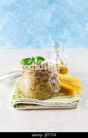 Italiano tipo di spaghetti bucatini e pesto di melanzana in vaso su marmo bianco tabella Foto Stock