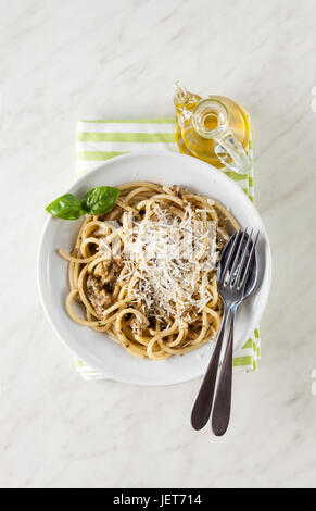 Italiano tipo di spaghetti bucatini e pesto di melanzana su marmo bianco tabella Foto Stock