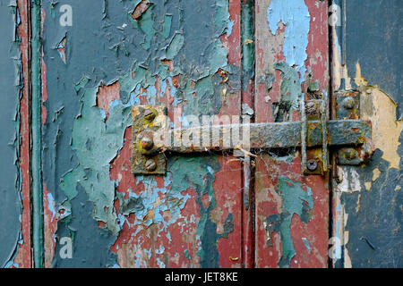 Il vecchio fermo di metallo su weathered porta capannone Foto Stock