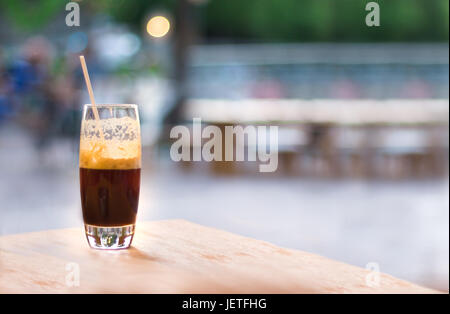 Un frappé caffè freddo caffè espresso su un tavolo all'aperto di sfondo sfocato. Foto Stock