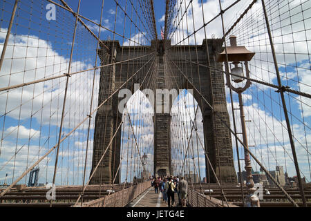 La gente camminare sopra il ponte di Brooklyn tra cavi New York City USA Foto Stock