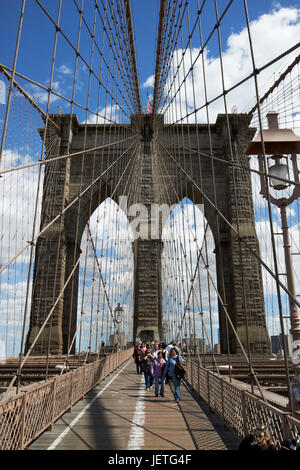 La gente camminare sopra il ponte di Brooklyn tra cavi New York City USA Foto Stock