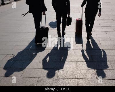 Die Schatten dreier Geschäftsleute, die mit ihren Rollkoffern zu einem Termin eilen. Foto: M. C. Hurek | Utilizzo di tutto il mondo Foto Stock
