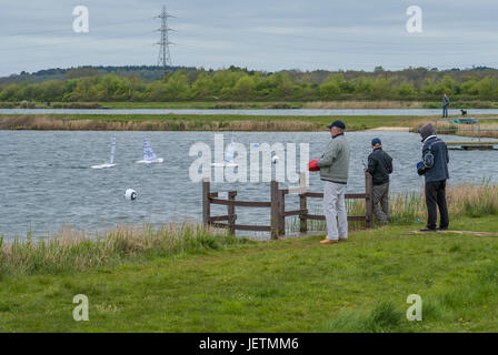 Gli uomini utilizzano radio controllo remoto del loro modello yachts su laghi a Longham, Dorset, England, Regno Unito Foto Stock