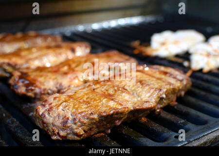 Succosa carne di manzo costate su barbecue grill. La messa a fuoco in primo piano. Foto Stock