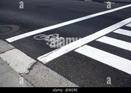 Pista ciclabile lungo la strada pedonale di attraversamento, vista ravvicinata al dipinto di bianco segna Foto Stock