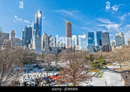 Central Park e la Skyline di inverno con la pista di pattinaggio su ghiaccio e neve Foto Stock