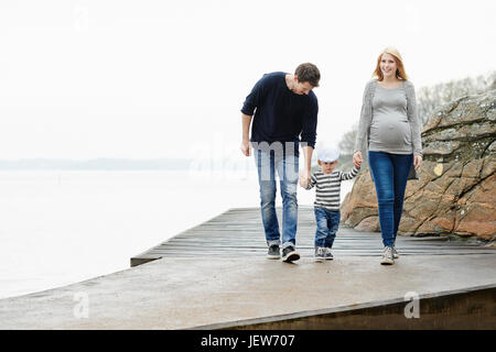 Famiglia con figlio camminando sul molo Foto Stock