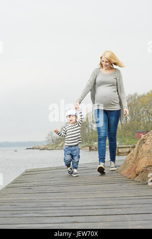 Donna con figlio camminando sul molo Foto Stock