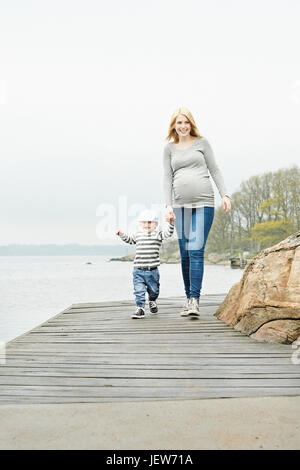 Donna con figlio camminando sul molo Foto Stock