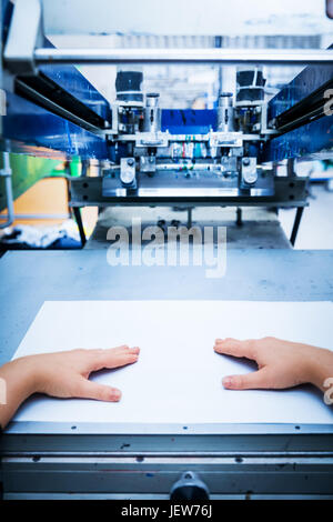 Lavoratore Prepara stampa screening macchina di metallo. Stampante industriale. Fabbricazione di lavoro. La prospettiva in prima persona. Foto Stock