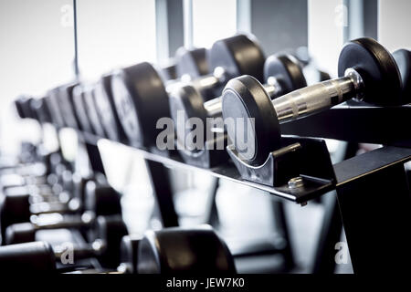 Righe di pesi su un rack in palestra. Sollevamento pesi, apparecchiature per il training. Foto Stock