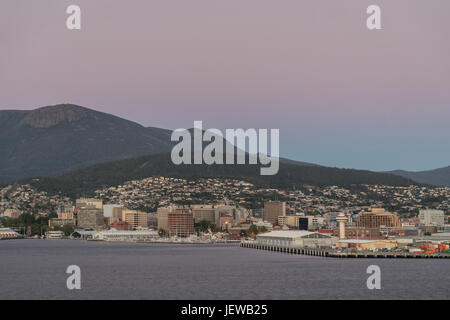 Hobart, Australia - marzo 19. 2017: la Tasmania. Rosa cielo sopra la montagna boscosa, lo sfondo del centro cittadino. La baia e il alto-sorge nei pressi della costa Foto Stock