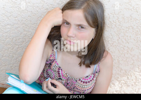 Un annoiato ragazza sta facendo il suo dovere Foto Stock