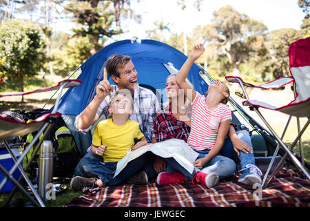 Famiglia seduto davanti a una tenda Foto Stock