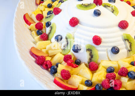 Mousse al formaggio con varie pezzo di frutta come frutti di bosco, mirtilli rossi, pinneaple, kiwi. Foto Stock