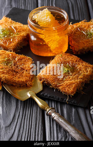 Bagno turco tradizionale kadayif dessert a base di pistacchio e miele di close-up sul tavolo. In verticale Foto Stock