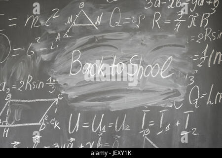 Le formule scritte in bianco gesso e si torna a scuola parole scritte sulla lavagna Foto Stock