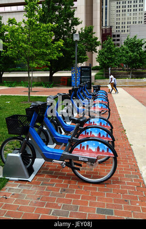 Pubblico di noleggiare le biciclette in docking station sul marciapiede nel centro di Baltimore, Maryland, Stati Uniti d'America Foto Stock