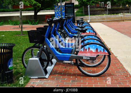 Pubblico di noleggiare le biciclette in docking station sul marciapiede nel centro di Baltimore, Maryland, Stati Uniti d'America Foto Stock