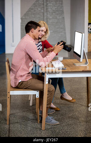 Team di fotografi a lavorare alla scrivania Foto Stock