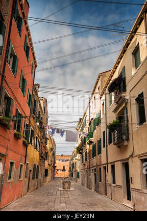 Stretta strada veneziana con pozzi per acqua e linee di lavaggio. Foto Stock
