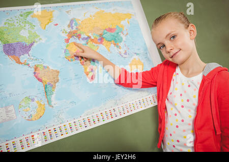 Ragazza puntando sulla mappa del mondo Foto Stock