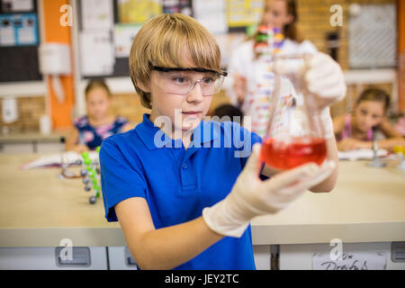 Bambino in posa con un liquido chimico Foto Stock