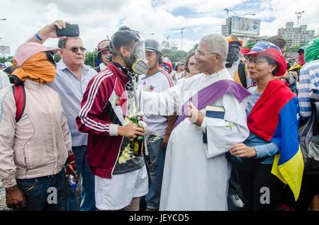 Un sacerdote benedice i manifestanti sulla superstrada. I dimostranti dell opposizione assemblato su Francisco Fajardo autostrada, vicino a Francisco de Miranda Air Force Foto Stock