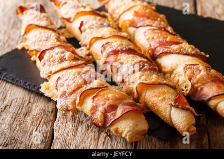 Pane appena sfornato bastoni con pancetta e formaggio vicino sul tavolo orizzontale. Foto Stock