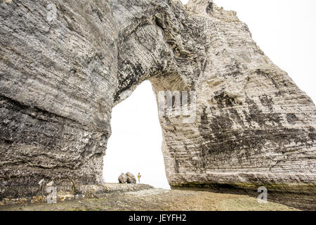 Panorama sulla grande scogliera di pietra con un foro e viaggiatori all'interno permanente Foto Stock