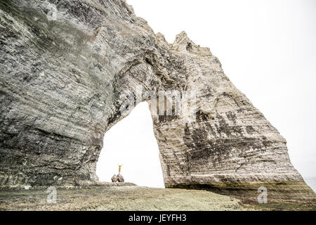 Panorama sulla grande scogliera di pietra con un foro e viaggiatori all'interno permanente Foto Stock