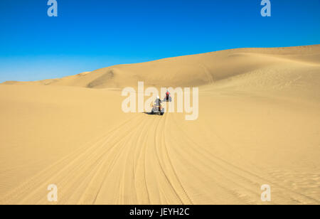 Quad la guida di persone - Due ciclisti felice nel deserto di sabbia. Foto Stock
