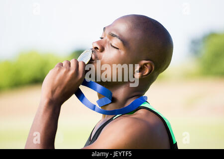 Atleta baciando la sua medaglia d'oro Foto Stock