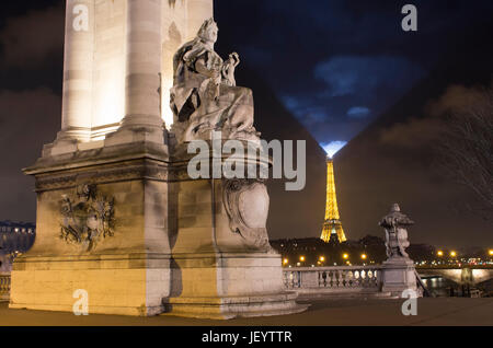 Vista notturna di scultura su Pont Alexandre III bridge. La torre Eiffel è sullo sfondo di Parigi. Foto Stock