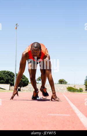 Atleta su un blocco di partenza circa per eseguire Foto Stock