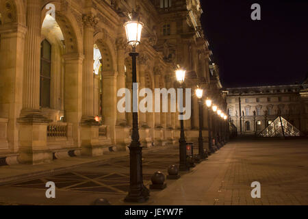 Vista notturna di luci di strada e il museo del Louvre (Musée du Louvre). Ex palazzo storico alloggiamento enorme collezione d'arte, da sculture romane di da Vinci Foto Stock