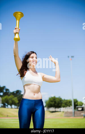 Atleta femminile tenendo una torcia di fuoco Foto Stock