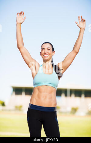 Felice atleta femminile in posa dopo una vittoria Foto Stock