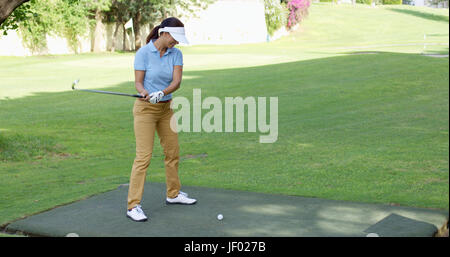 Giovani femmine golfista preparando a tee off Foto Stock