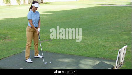 Giovani femmine golfista preparando a tee off Foto Stock