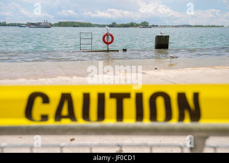 Il termine " caution " nastro giallo nella parte anteriore di allagamento del lungolago in Toronto Foto Stock