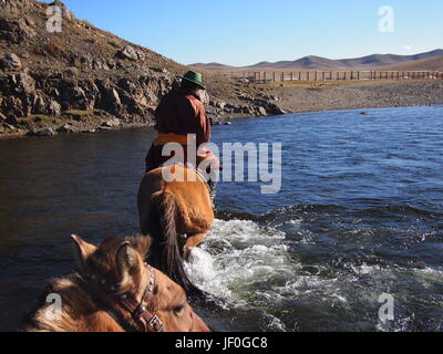 Gorkhi Terelj National Park, Mongolia - 01 Ottobre 2016: il mongolo herder che attraversa un fiume a cavallo Foto Stock